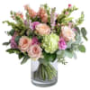 This enchanting floral arrangement blends soft peach hues with delicate greens and