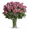 Pink roses arranged in a clear glass vase with white filler flowers