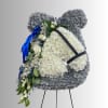 Large white and silver floral standing spray on an easel with blue ribbon