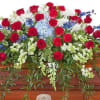 This beautiful red, white and blue casket spray gives tribute to the