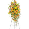 Tall floral standing spray with orange roses and yellow sunflowers on a metal easel