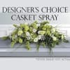 Green and white casket spray with mixed flowers on a gray casket
