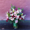 Bouquet of pink lilies and red roses in a glass vase
