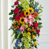 A vibrant and uplifting standing spray designed with a beautiful garden-inspired mix