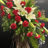 Large floral spray with white lilies and red carnations on a twig base