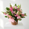 Pink floral basket arrangement with roses, lilies, and snapdragons