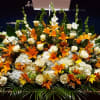Large altar-style arrangement of orange lilies and white roses with hydrangeas in a low horizontal design