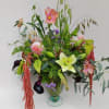 Tall garden-style arrangement with pink dahlias, green lily, dark calla lilies in a clear glass vase