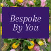 Colorful mixed flowers blurred behind a purple panel with the words Bespoke By You.