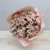 Large bouquet of pale pink spray roses wrapped in soft pink paper