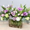 Lavender and blush tulips mingle with ruffled ranunculus and creamy roses in