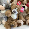 Plush stuffed animals with red gift tags are piled together