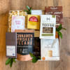 Assorted gourmet snack gift set with packaged treats on a wooden surface