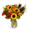 Bouquet of sunflowers, orange roses, and carnations in a clear glass vase