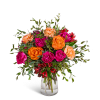 Bouquet of orange and magenta roses with peach carnations in a clear glass vase