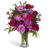 Pink roses and magenta carnations in a clear glass vase