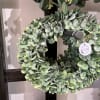 Round wreath of dense green foliage on a display stand