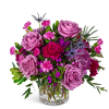 Lavender roses and pink mixed flowers in a clear glass vase