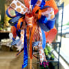 Decorative ribbon bow in blue, orange, and white with basketball patterns