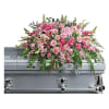 Pink floral casket spray on a silver casket