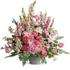Pink lilies and roses arranged in a gray vase