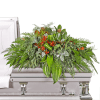 Large floral casket spray with red blooms and mixed greenery on a silver casket