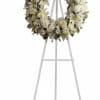 White floral wreath on a tall metal easel