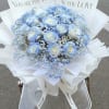 Blue and white rose bouquet with baby's breath in white wrap