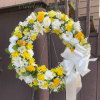 A bright circular wreath that reads as both celebratory and respectfully composed-perfect