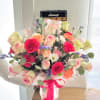 Mixed bouquet of pink and cream roses with carnations and daisies in pink wrap
