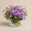 A compact dome of five lavender roses creates a calm, romantic focal