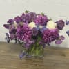 Purple and white mixed bouquet in a clear glass vase