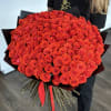 Large bouquet of red roses wrapped in black paper with a red ribbon