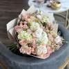 Bouquet of pink and white roses with pale hydrangeas in paper wrap