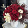 Red and white roses arranged in a white face vase
