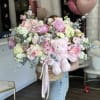 Large pink and white flower arrangement with a teddy bear in a woven basket