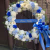 A large circular sympathy wreath in serene white and blue offers a