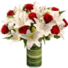 Red roses and white lilies arranged in a green glass vase