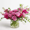 Pink roses and magenta flowers in a clear glass vase