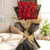 Bouquet of red roses wrapped in black and beige paper