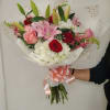 Hand-tied bouquet of pink lilies, roses, and white hydrangeas wrapped with pink ribbon.