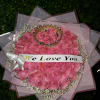 Round bouquet of pink roses with baby’s breath, crown accent, and a ‘We Love You’ banner.