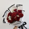 Bouquet of red roses wrapped in white paper with black trim
