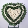 Heart-shaped floral wreath of white roses on a stand