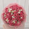 Bouquet of pink roses and white alstroemeria wrapped in pink tissue