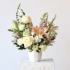 Mixed bouquet of roses and lilies in a white vase