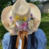 Straw hat decorated with pastel flowers and ribbon