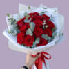 Bouquet of red roses wrapped in white paper with a red ribbon
