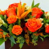 This radiant arrangement pairs cheerful sunflowers with vibrant orange roses and seasonal