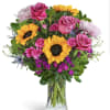 Bouquet of pink roses and sunflowers in a clear glass vase